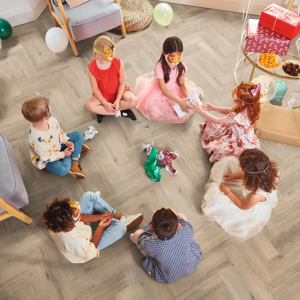 Van Gogh Canadiuan Urban Oak herringbone mid brown LVT flooring with children sat down